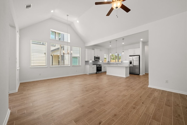 208 Cider Gum Pl, Montgomery, TX 77316 - unfurnished living room featuring a ceiling fan, high vaulted ceiling, light wood-type flooring, baseboards, and recessed lighting
