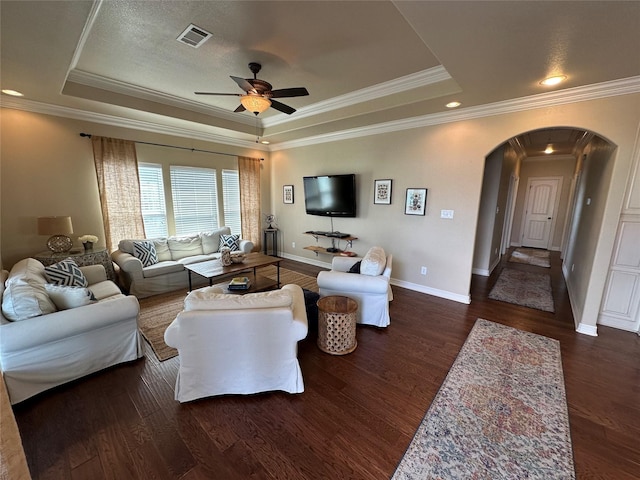 2029 Idyle Vw, Crystal Beach, TX 77650 - living area featuring a raised ceiling, arched walkways, wood finished floors, ceiling fan, and baseboards