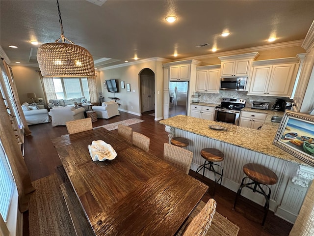 2029 Idyle Vw, Crystal Beach, TX 77650 - kitchen featuring stainless steel appliances, arched walkways, open floor plan, baseboards, and a peninsula