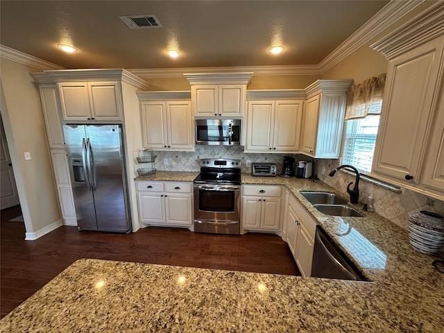 2029 Idyle Vw, Crystal Beach, TX 77650 - kitchen with appliances with stainless steel finishes, a sink, dark wood finished floors, light stone countertops, and backsplash