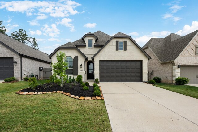 15827 Bird Of Paradise Dr, Conroe, TX 77302 - french provincial home with a front yard, driveway, brick siding, and roof with shingles