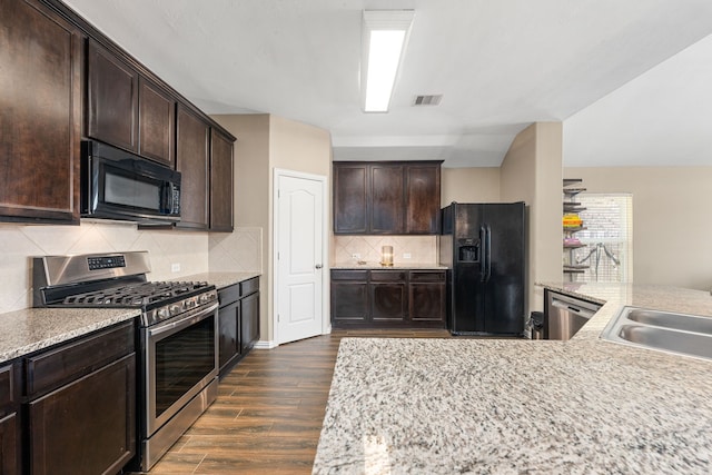 26511 Green Heron, Katy, TX 77494 - kitchen featuring black appliances, dark wood-style floors, dark brown cabinetry, tasteful backsplash, and a sink