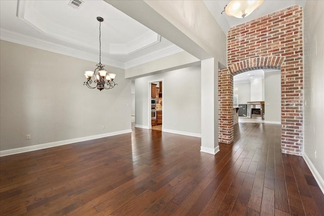 3490 Prescott Dr, Beaumont, TX 77706 - empty room with dark wood-type flooring, a fireplace, a chandelier, baseboards, and a tray ceiling