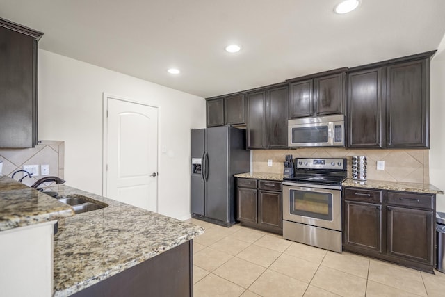 18724 Carrizo Trl, Magnolia, TX 77355 - kitchen featuring stainless steel appliances, a sink, dark brown cabinetry, and recessed lighting