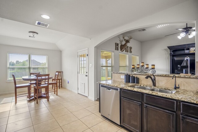 18724 Carrizo Trl, Magnolia, TX 77355 - kitchen featuring stainless steel dishwasher, a sink, baseboards, arched walkways, and recessed lighting