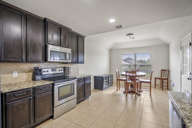 18724 Carrizo Trl, Magnolia, TX 77355 - kitchen with stainless steel appliances, backsplash, light stone countertops, dark brown cabinets, and recessed lighting