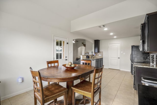 18724 Carrizo Trl, Magnolia, TX 77355 - dining room with arched walkways, light tile patterned floors, baseboards, and recessed lighting