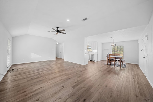 3009 Fm 50, Brenham, TX 77833 - unfurnished living room with wood finished floors, vaulted ceiling, baseboards, a ceiling fan, and a chandelier