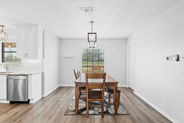 3009 Fm 50, Brenham, TX 77833 - dining area with light wood finished floors, a chandelier, and baseboards