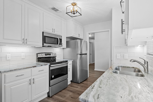 3009 Fm 50, Brenham, TX 77833 - kitchen with appliances with stainless steel finishes, a sink, white cabinets, tasteful backsplash, and a chandelier