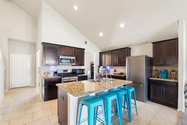 2910 High Garden Ln, Fresno, TX 77545 - kitchen with appliances with stainless steel finishes, a sink, backsplash, high vaulted ceiling, and a kitchen bar