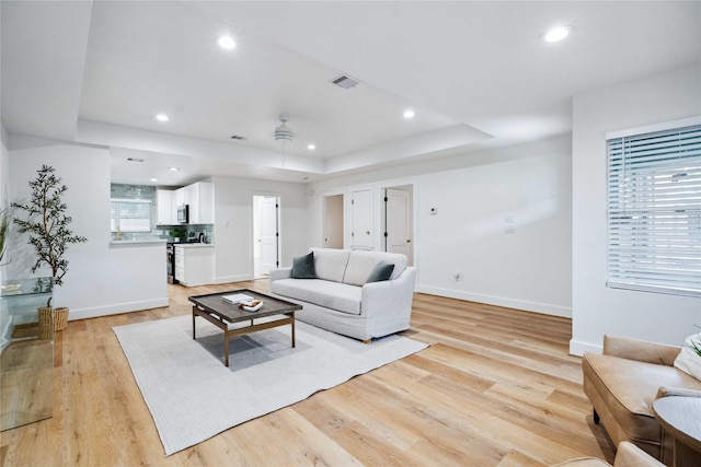 6019 Westover St, Houston, TX 77033 - living room featuring light wood-style flooring, baseboards, recessed lighting, and a raised ceiling