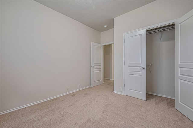 24511 Carlton Springs Ln, Katy, TX 77494 - unfurnished bedroom with light colored carpet, baseboards, a closet, and a textured ceiling
