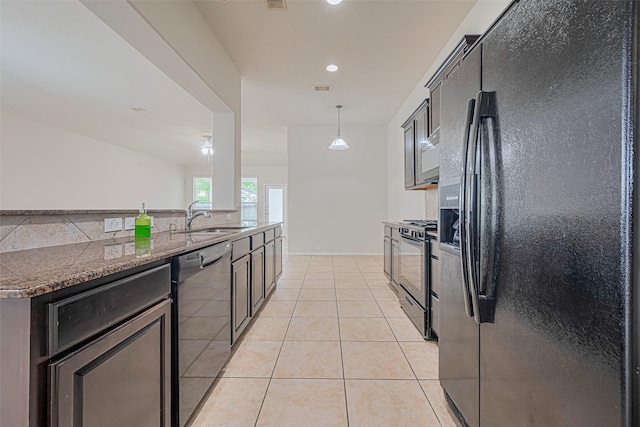 24511 Carlton Springs Ln, Katy, TX 77494 - kitchen with black appliances, a sink, light tile patterned floors, dark stone counters, and recessed lighting
