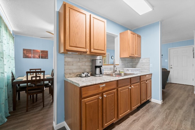 21 Clearview St, Point Blank, TX 77364 - kitchen featuring a sink, wood finished floors, light countertops, ornamental molding, and backsplash