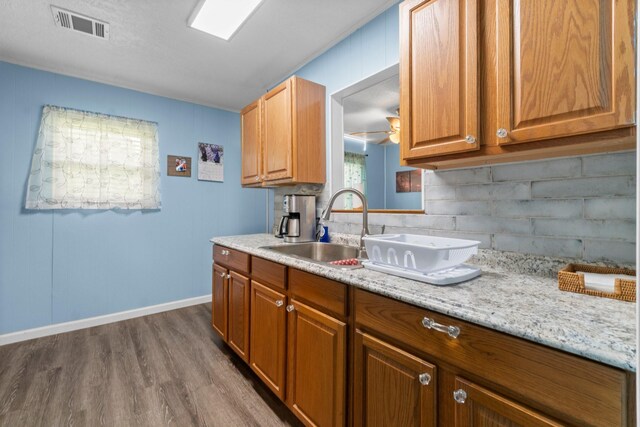 21 Clearview St, Point Blank, TX 77364 - kitchen featuring a sink, dark wood finished floors, decorative backsplash, baseboards, and brown cabinetry