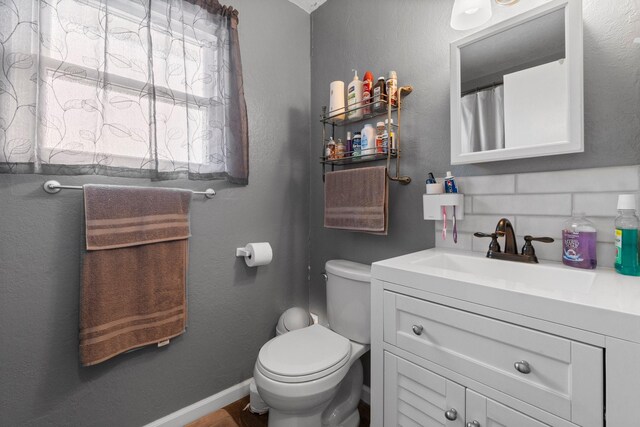 21 Clearview St, Point Blank, TX 77364 - full bathroom with vanity, toilet, baseboards, backsplash, and wood finished floors
