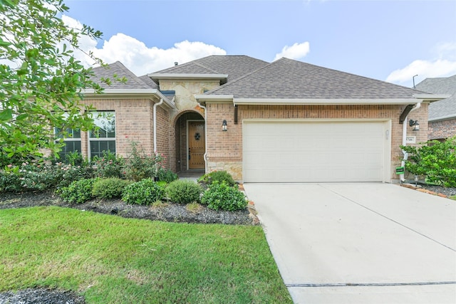 5746 Bobwhite Trl, Manvel, TX 77578 - view of front of house featuring a shingled roof, driveway, an attached garage, a front yard, and brick siding
