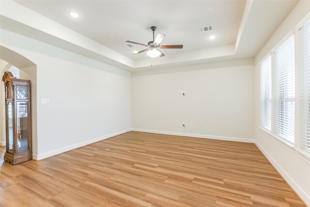 5746 Bobwhite Trl, Manvel, TX 77578 - empty room with a tray ceiling, a ceiling fan, plenty of natural light, arched walkways, and recessed lighting