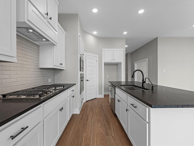 14690 Hereford Grove Ln, Montgomery, TX 77316 - kitchen featuring a sink, appliances with stainless steel finishes, dark countertops, an island with sink, and dark wood-style floors