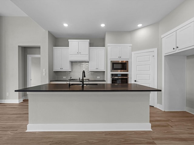 14690 Hereford Grove Ln, Montgomery, TX 77316 - kitchen featuring oven, built in microwave, a sink, dark countertops, and white cabinets
