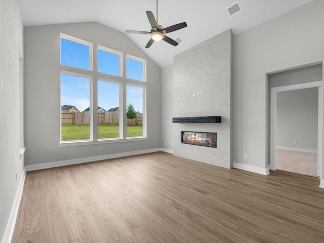 14690 Hereford Grove Ln, Montgomery, TX 77316 - unfurnished living room with wood finished floors, a large fireplace, ceiling fan, high vaulted ceiling, and baseboards