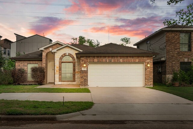5106 Hardy St, Houston, TX 77009 - view of front of home featuring a garage, driveway, brick siding, and roof with shingles