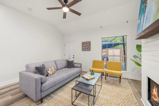 5106 Hardy St, Houston, TX 77009 - living room with light wood finished floors, a ceiling fan, baseboards, vaulted ceiling, and a large fireplace