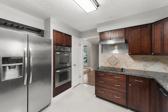 2407 Rambling Brook Dr, Spring, TX 77373 - kitchen with appliances with stainless steel finishes, backsplash, under cabinet range hood, light floors, and a textured ceiling