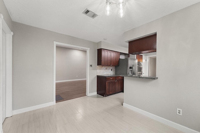 2407 Rambling Brook Dr, Spring, TX 77373 - kitchen with appliances with stainless steel finishes, backsplash, a chandelier, baseboards, and a textured ceiling