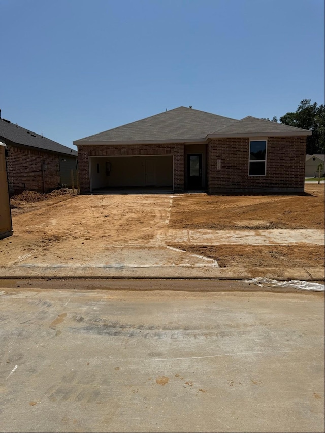 10300 Woodhill Spa Ln, Cleveland, TX 77327 - view of front of house featuring an attached garage, driveway, and brick siding