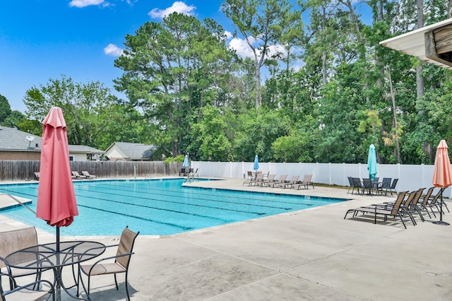 999 Arbor Xing, Conroe, TX 77303 - community pool with a patio area, outdoor dining space, and view of wooded area