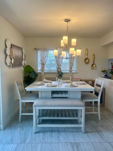 17102 Dewgrass Dr, Houston, TX 77060 - dining space featuring a chandelier and baseboards