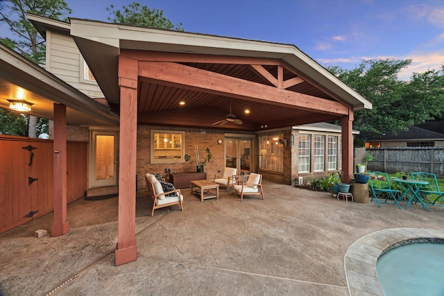 15907 Turtle Bay Dr, Houston, TX 77062 - patio terrace at dusk with a ceiling fan, fence, and an outdoor hangout area