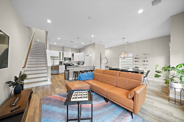 413 Stonework Oaks Ln, Houston, TX 77076 - living area featuring light wood finished floors, stairs, recessed lighting, baseboards, and a chandelier