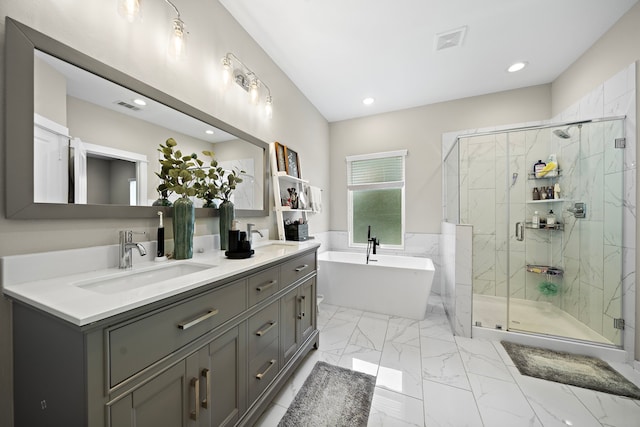 413 Stonework Oaks Ln, Houston, TX 77076 - bathroom featuring a freestanding bath, a marble finish shower, double vanity, marble finish flooring, and recessed lighting