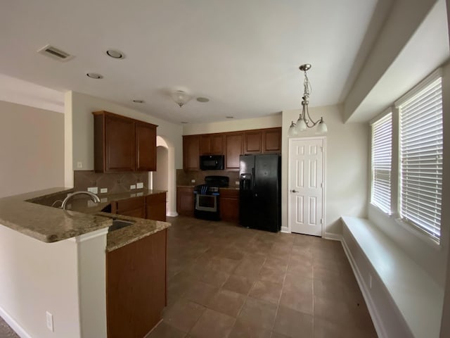 3603 Morgans Cove Ct, Katy, TX 77494 - kitchen with black appliances, a sink, tasteful backsplash, light stone countertops, and a peninsula