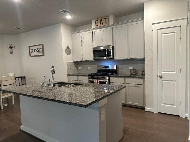 12148 Brazos Dr, Willis, TX 77378 - kitchen featuring stainless steel appliances, a sink, dark wood-style floors, and decorative backsplash