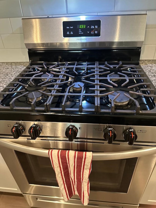 12148 Brazos Dr, Willis, TX 77378 - kitchen view of stainless steel gas stove and tasteful backsplash