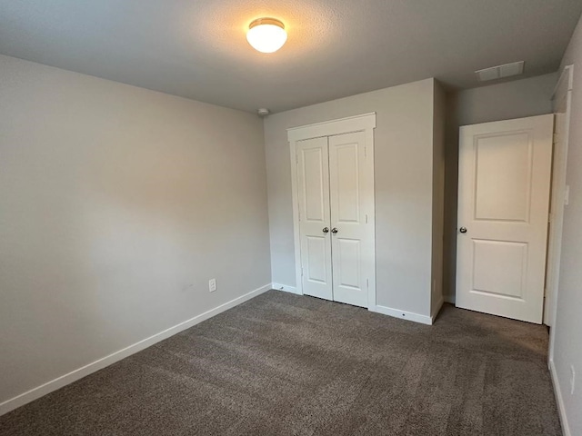 12148 Brazos Dr, Willis, TX 77378 - unfurnished bedroom with dark carpet, baseboards, and a closet