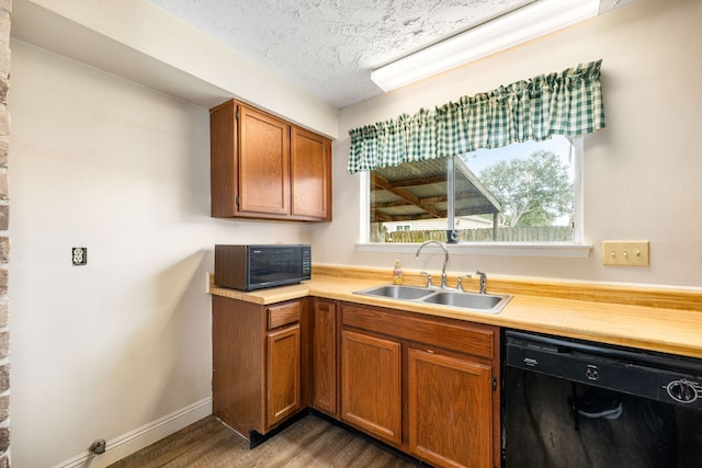 7802 Tarik Dr, Houston, TX 77083 - kitchen with a sink, black appliances, light countertops, wood finished floors, and baseboards
