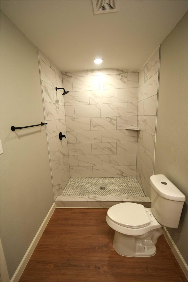 8130 Sharondale Dr, Houston, TX 77033 - bathroom featuring toilet, a tile shower, wood finished floors, baseboards, and recessed lighting