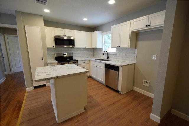 8130 Sharondale Dr, Houston, TX 77033 - kitchen with stainless steel appliances, a sink, backsplash, a center island, and light stone counters
