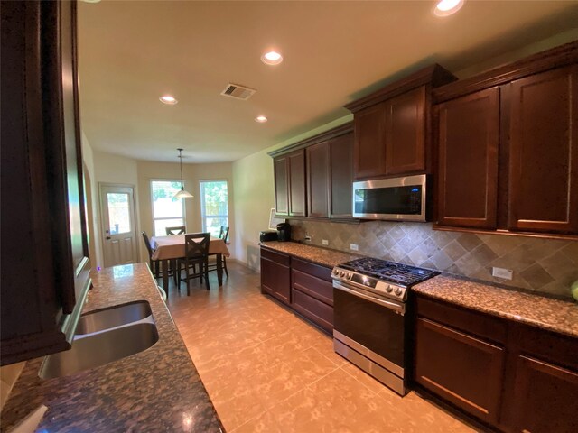 15 S Marshside Pl, Spring, TX 77389 - kitchen with appliances with stainless steel finishes, recessed lighting, decorative backsplash, dark brown cabinetry, and a sink