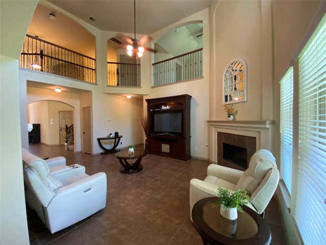 15 S Marshside Pl, Spring, TX 77389 - living area featuring arched walkways, a fireplace, ceiling fan, and a high ceiling