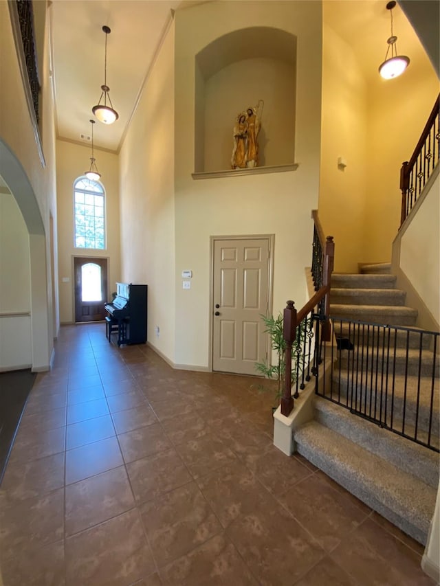 15 S Marshside Pl, Spring, TX 77389 - tiled entryway featuring a high ceiling, stairway, baseboards, arched walkways, and crown molding