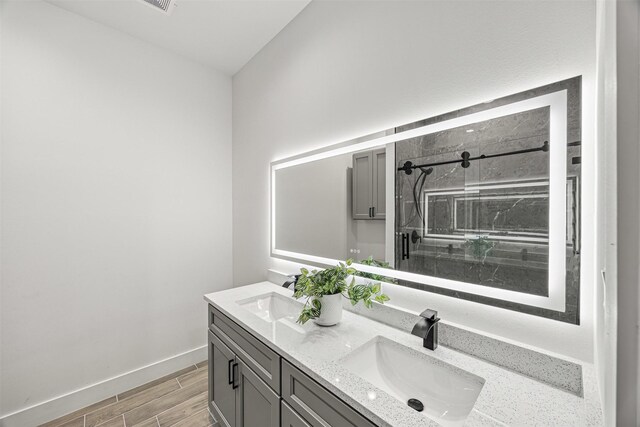 316 E Oakdale St, Dayton, TX 77535 - full bathroom with a shower stall, double vanity, wood tiled floors, and baseboards