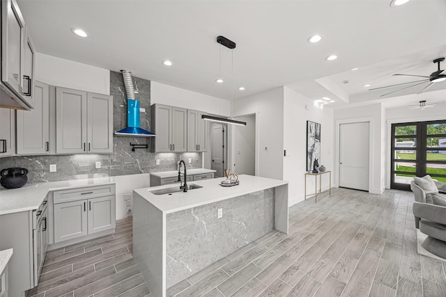 316 E Oakdale St, Dayton, TX 77535 - kitchen with a sink, gray cabinetry, backsplash, wall chimney range hood, and recessed lighting