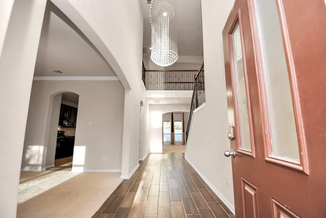 14542 Northern Mountain Ct, Houston, TX 77090 - foyer with a chandelier, arched walkways, baseboards, crown molding, and wood finished floors