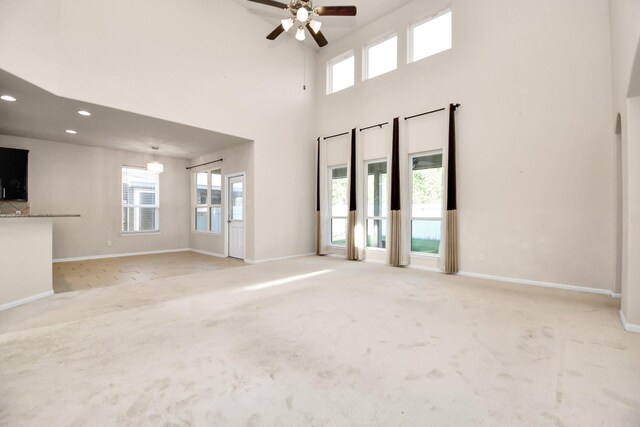 14542 Northern Mountain Ct, Houston, TX 77090 - unfurnished living room with a ceiling fan, carpet floors, baseboards, recessed lighting, and a high ceiling